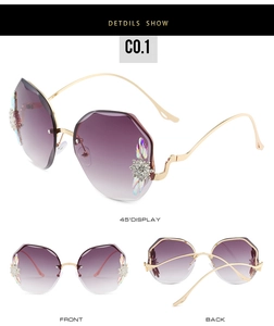 Détail de lunettes de soleil sans monture violet dégradé avec fleurs en strass chic