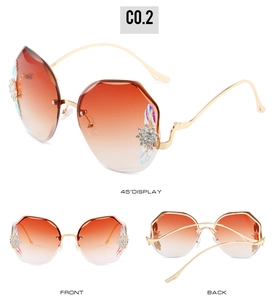 Détail de lunettes de soleil sans monture dégradées avec cristaux et branches dorées
