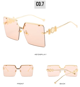 Detail view of square oversized sunglasses with gold metal frames and orange lenses