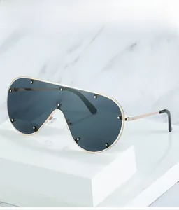 Détail de lunettes aviateur en métal avec rivets argentés et verres gris surdimensionnés