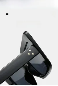 Detail of black cat-eye sunglasses featuring three gold rivets and flexible hinges