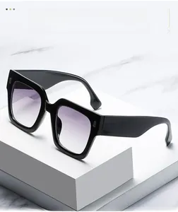 Detail of oversized square sunglasses with black thick frames and purple gradient lenses