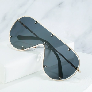 Lunettes de soleil bouclier oversize avec monture dorée et rivets sur verres foncés