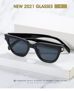 Detail of black cat-eye glasses frame with silver metal hinge and blue light protection