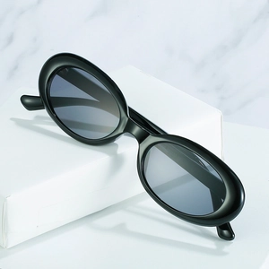 Retro oval black sunglasses with thick frames and dark grey lenses for a vintage look