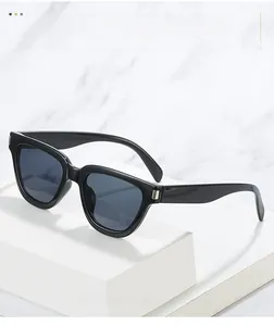 Close-up of black oversized sunglasses with silver metal decorative hinges on a marble stand