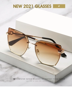 Detail of fashion rimless square sunglasses with gold metal horsebit hinge and brown lenses