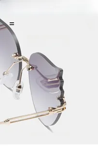 Détail de lunettes de soleil flamme sans monture avec verres dégradés violets et monture dorée