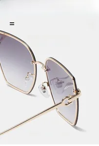 Detail of gradient purple lenses and double ring metal hinge on rimless sunglasses