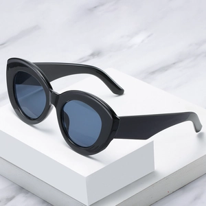 Chic black cat eye oversized sunglasses with blue lenses on a marble background