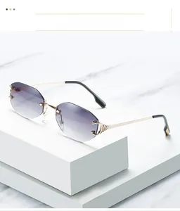 Détail de lunettes de soleil sans monture avec décor C doré sur fond de marbre