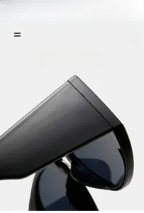 Detail of black oversized round sunglasses showing glossy resin frame and hinges
