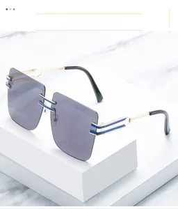 Detail of oversized rimless square sunglasses with grey lenses and gold metal temples
