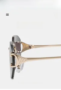 Détail de lunettes de soleil sans monture avec branches dorées et ornement en D