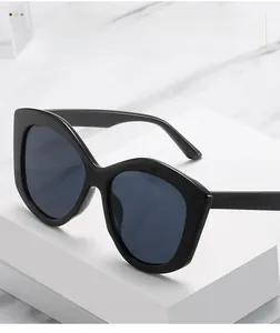 Détail de lunettes de soleil œil-de-chat noires oversize avec monture géométrique