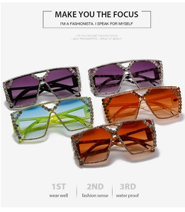 Close-up of oversized square sunglasses featuring full rhinestone frames in various colors