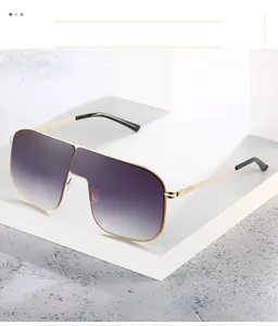 Dettaglio occhiali da sole oversize in metallo con lenti sfumate viola su base bianca