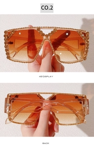 Macro detail of oversized square sunglasses with amber lenses and champagne rhinestones
