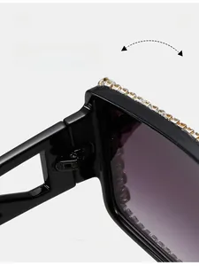 Detail of durable metal hinges and sparkling rhinestones on black oversized sunglasses