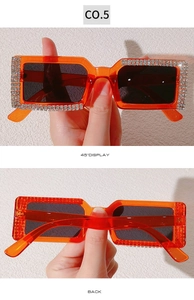 Macro shot of rectangular translucent orange sunglasses with luxury rhinestone encrusting