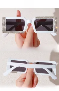 Detail showing dense rhinestone inlays on thick white rectangle frame sunglasses