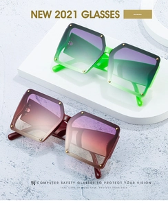 Detail of square oversized sunglasses with gold rivets and colorful gradient lenses