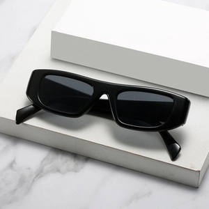 Vintage rechteckige schwarze Sonnenbrille auf weißem Display vor Marmorhintergrund