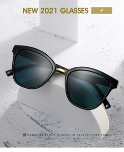 Close-up of black safety glasses with gold metal accents on white geometric props