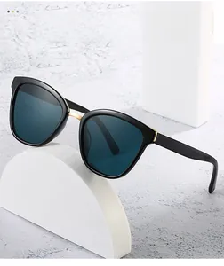 Detail of retro square sunglasses with dark blue lenses and gold metal nose bridge