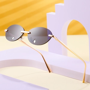 Rahmenlose ovale Sonnenbrille mit rauchgrauen Gläsern und goldenen Metallbügeln im Trend