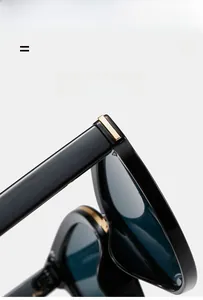 Close-up of black retro sunglasses featuring gold metal hinge detail and premium texture