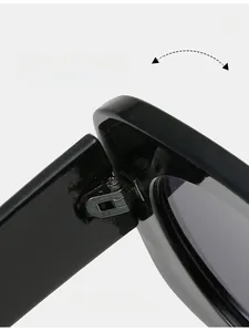 Close-up of the durable reinforced metal hinge structure on bright black sunglasses