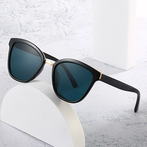 Retro oversized sunglasses with thick black frames and gold accents on marble background