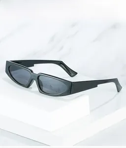 Close-up of stylish black narrow cat-eye sunglasses on a white geometric platform