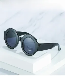 Macro detail of retro oversized round sunglasses with thick black frames on white display