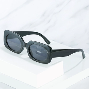 Retro black chunky rectangle sunglasses with dark gray lenses for women on marble base