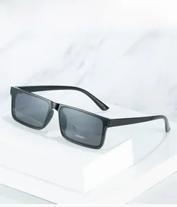 Detail of minimalist black rectangular sunglasses on a white stand with marble background