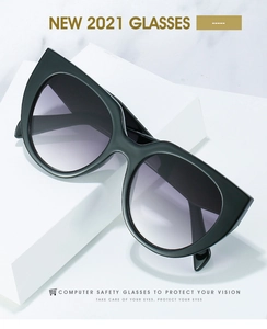 Cat-eye sunglasses with black frame and purple gradient lenses on marble stand
