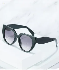 Detail view of bold oversized sunglasses with black geometric frame and gradient lenses
