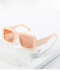 Makroansicht der dicken rosa quadratischen Sonnenbrille mit orangefarbenen Verlaufsgläsern