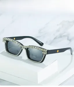 Close-up of luxury square sunglasses with shimmering rhinestones and gold accents