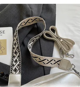 Detail of set including a geometric woven wide strap and a cream PU leather shoulder strap