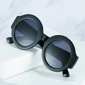 Retro oversized round sunglasses in black with unique pointed corners on marble background