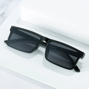 Minimalist black rectangular sunglasses with dark lenses on a marble background