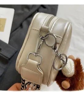 Detail of champagne leather handbag featuring premium silver hardware and wide woven strap