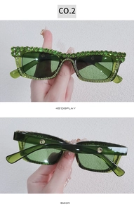 Close-up of green rhinestone square sunglasses with crystal-encrusted frames and lenses