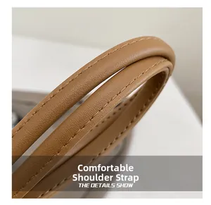 Macro shot of comfortable leather shoulder strap with durable stitching on tan handbag