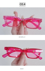 Close-up of pink Y2K rectangle sunglasses featuring sparkling rhinestones and tinted lenses
