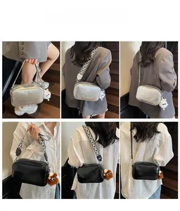 Detail view of stylish square crossbody bags with geometric straps and plush eye charms