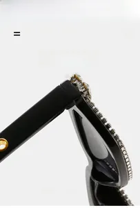 Detail of square black Y2K sunglasses with sparkling rhinestones and golden leg accent